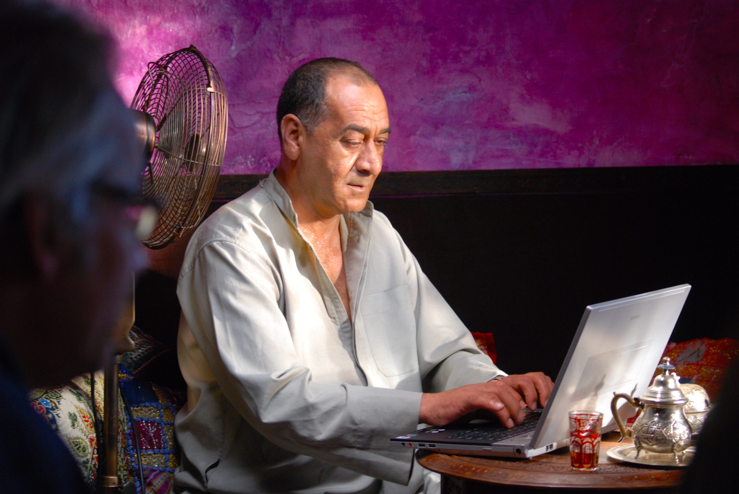 Man typing in a lap top. Shooting in a bar of Nerja a tv commercial for E.ON©